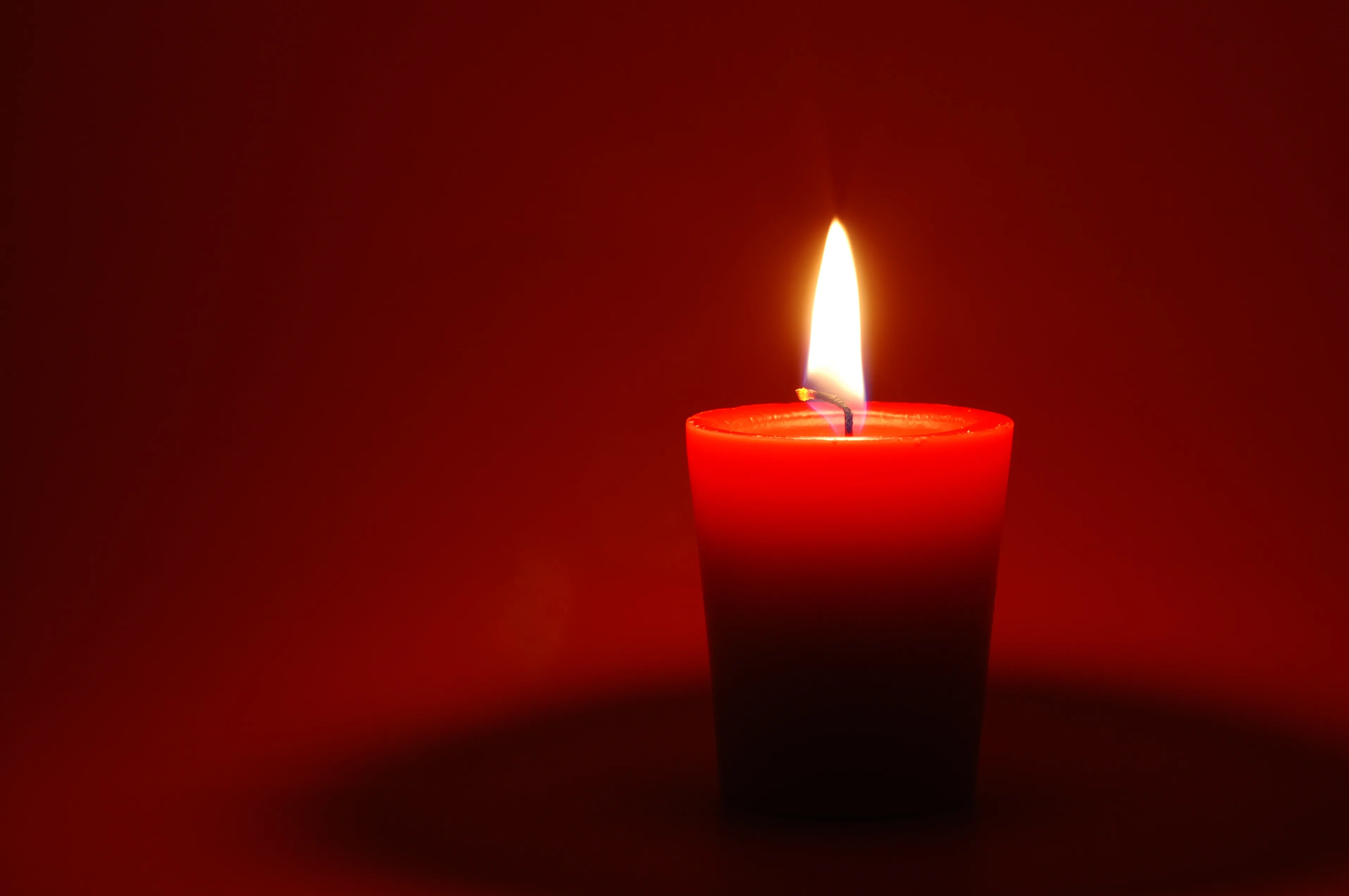 A red candle on red background