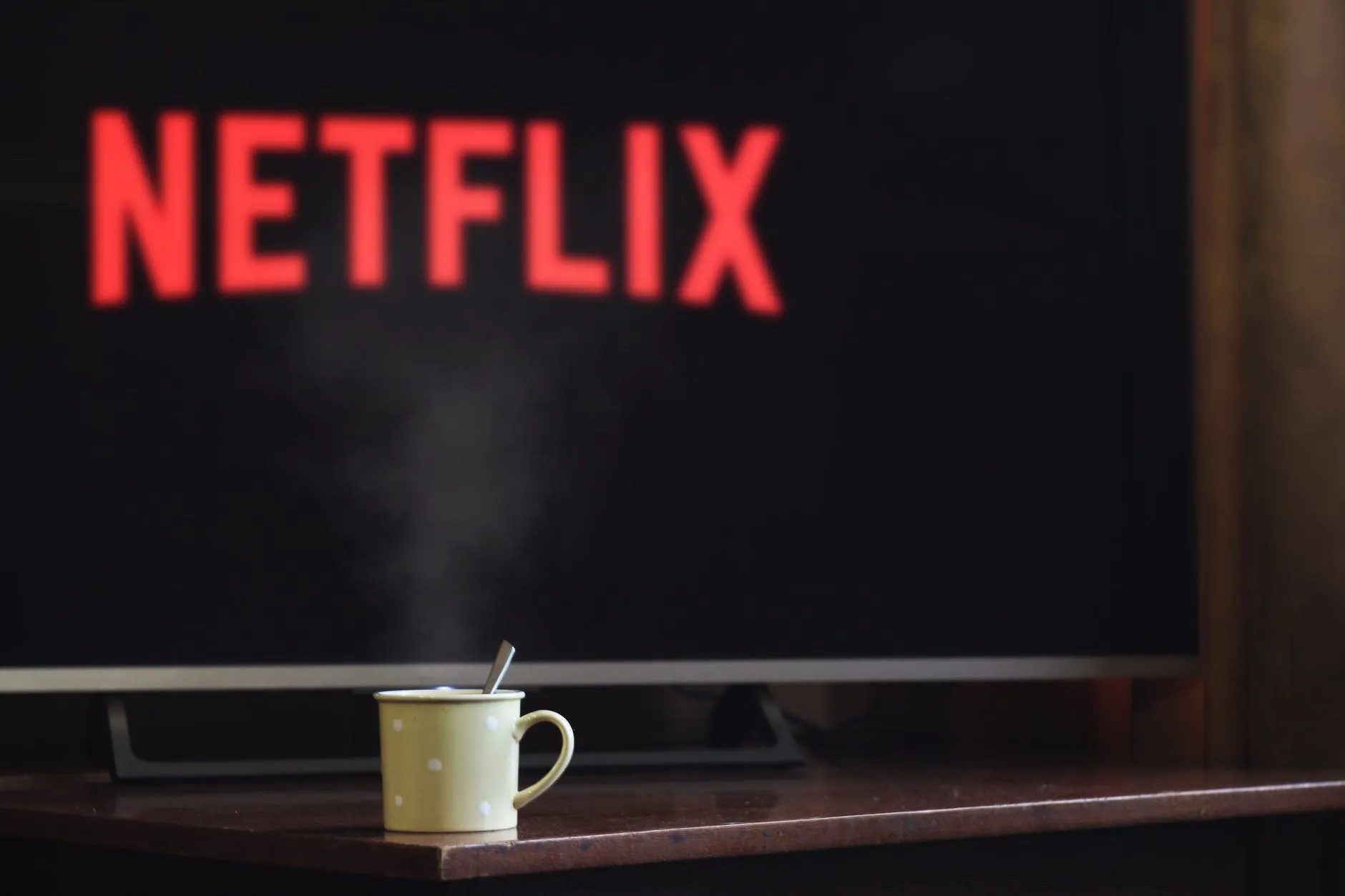 Coffee cup with blurred Netflix logo in the background
